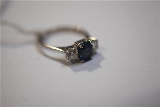 A modern 18ct white gold and three stone diamond and sapphire ring, size J.